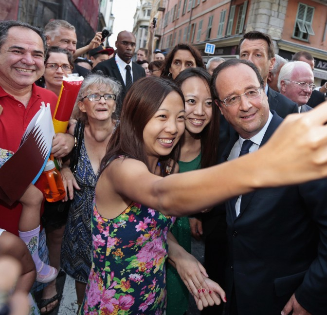 Chinese tourists snap a selfie with France’s president in Paris. 